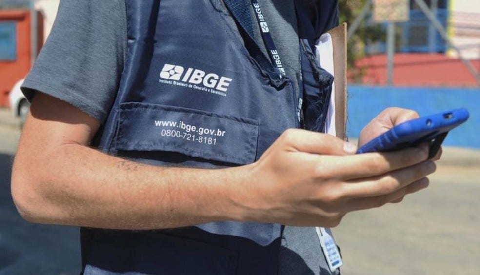 Recenseador do IBGE utilizando smartphone durante coleta de dados